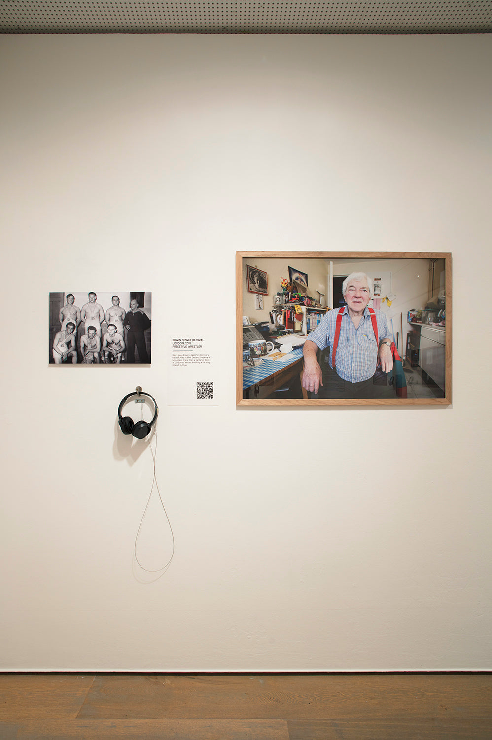 Art installation with framed photographs and a QR code on a wall.