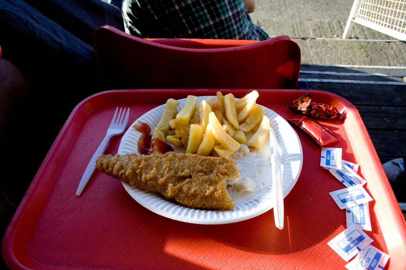 Tray with fish and chips on a red tray outdoors