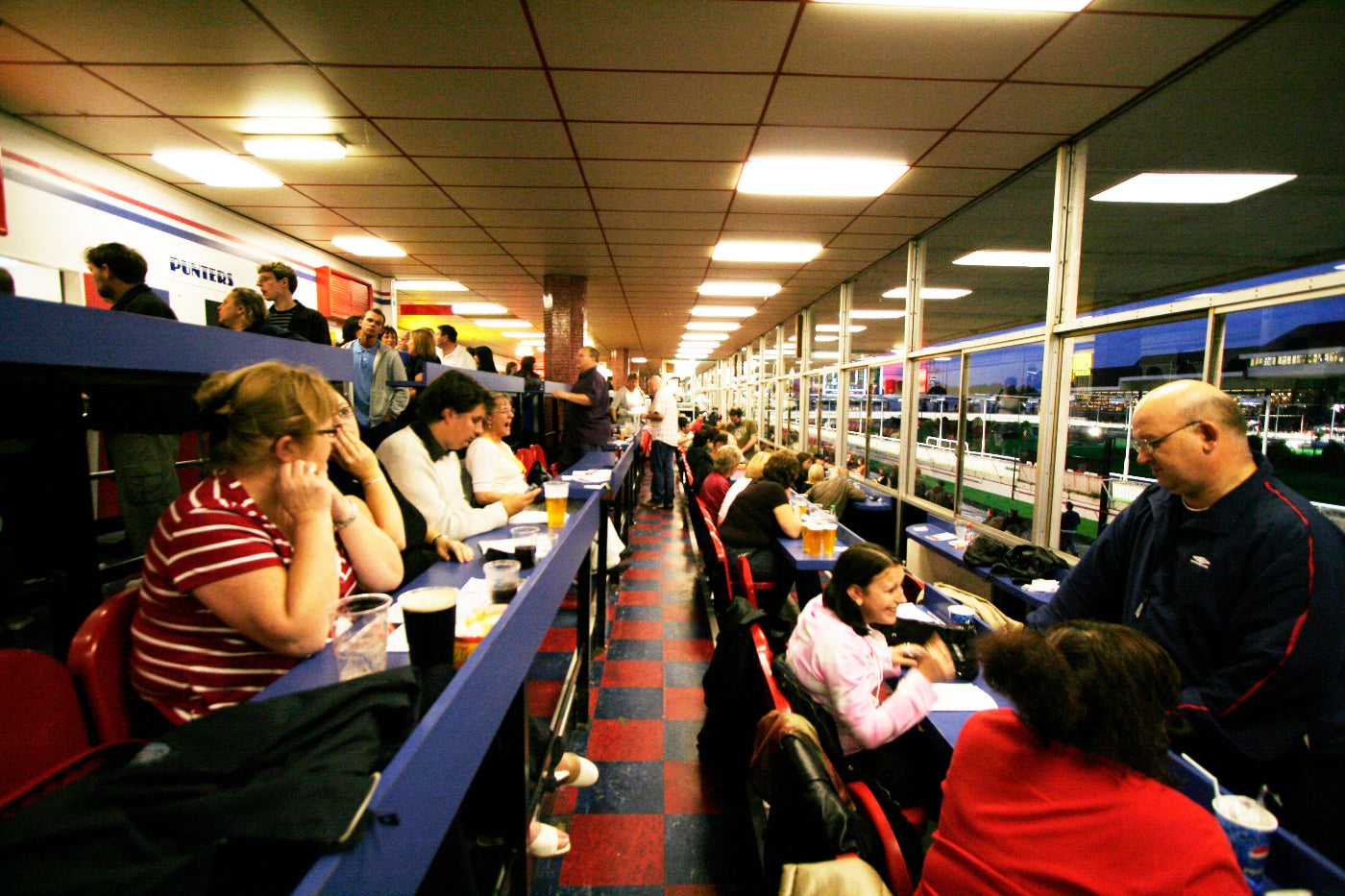 People sitting at a counter looking at over Walthamstow Dogs track