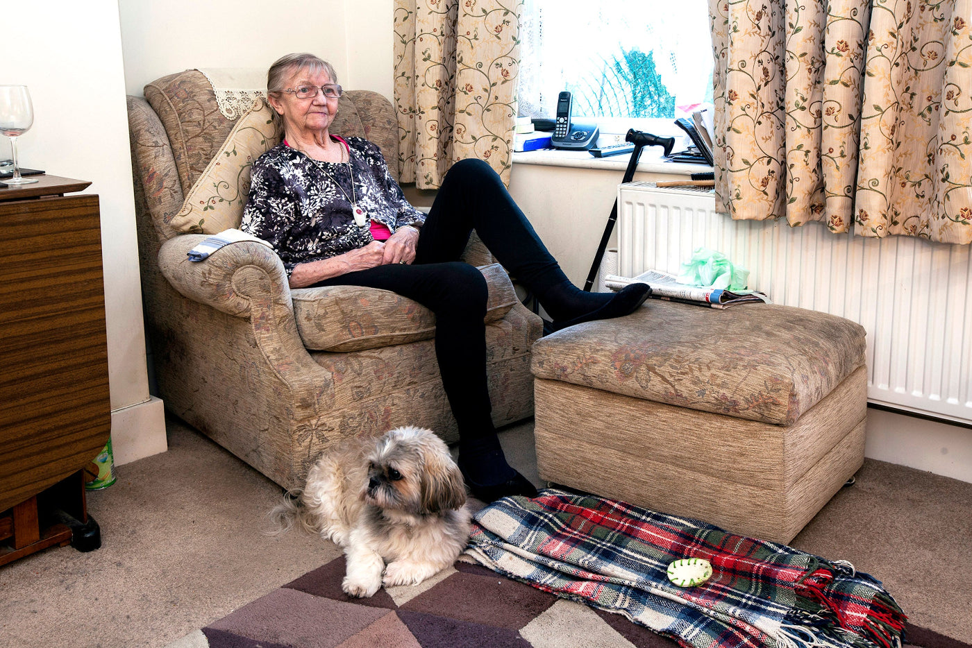Woman sitting in a living room with a dog on the floor