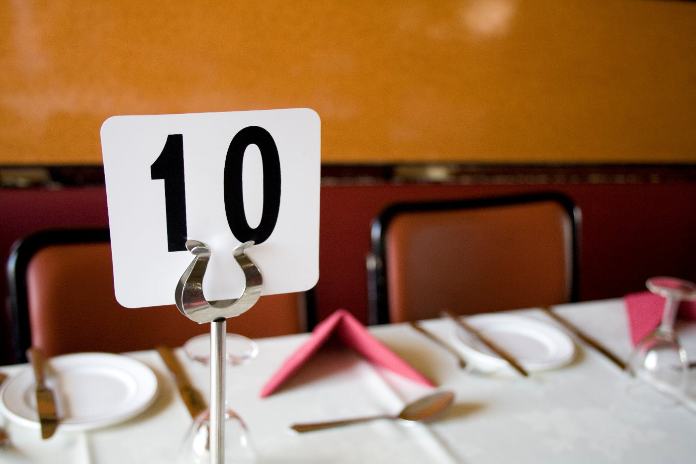 Table setting with a number 10 sign on a table in a room.