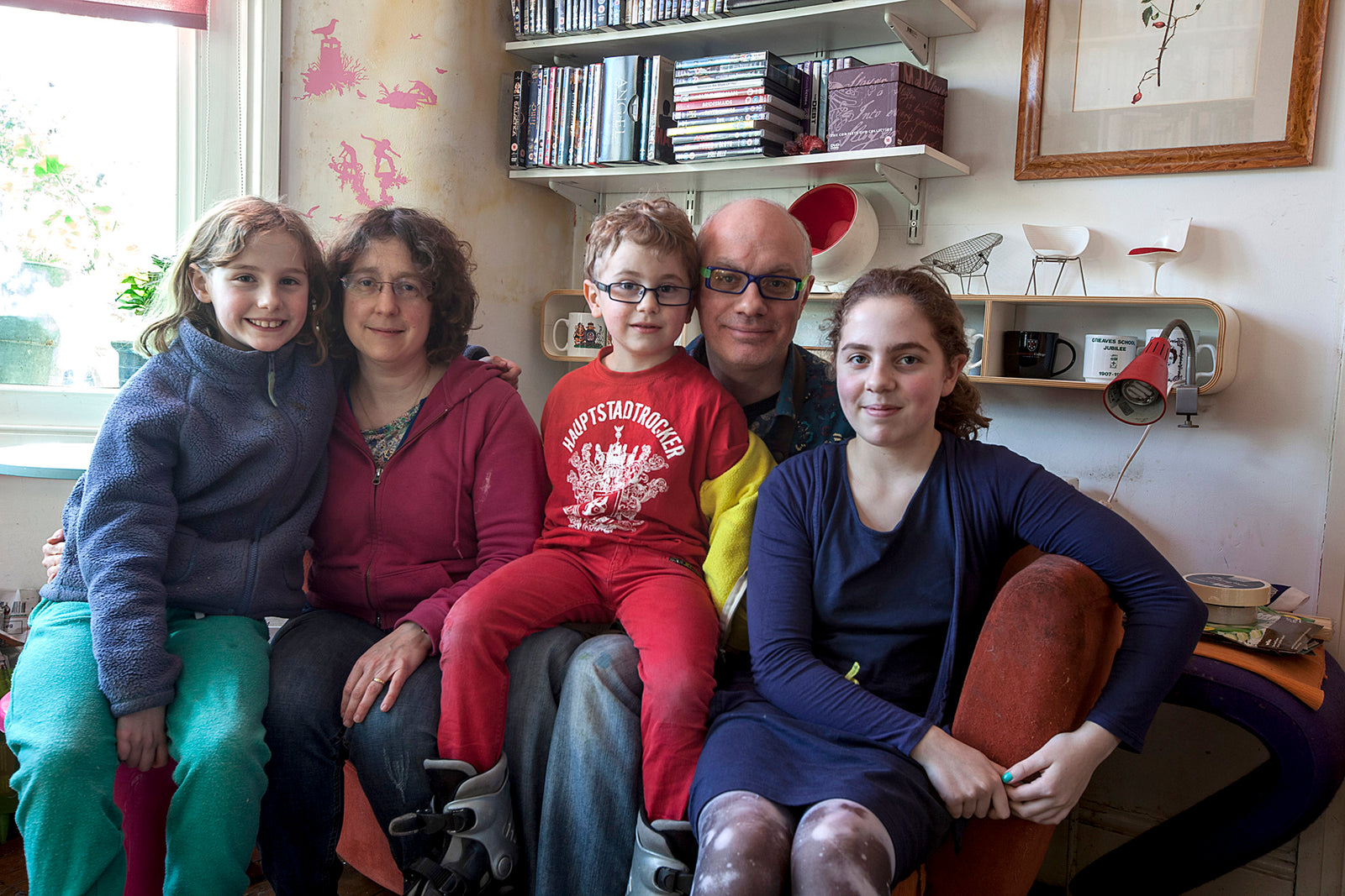 Family of five sitting together in a cozy living room.