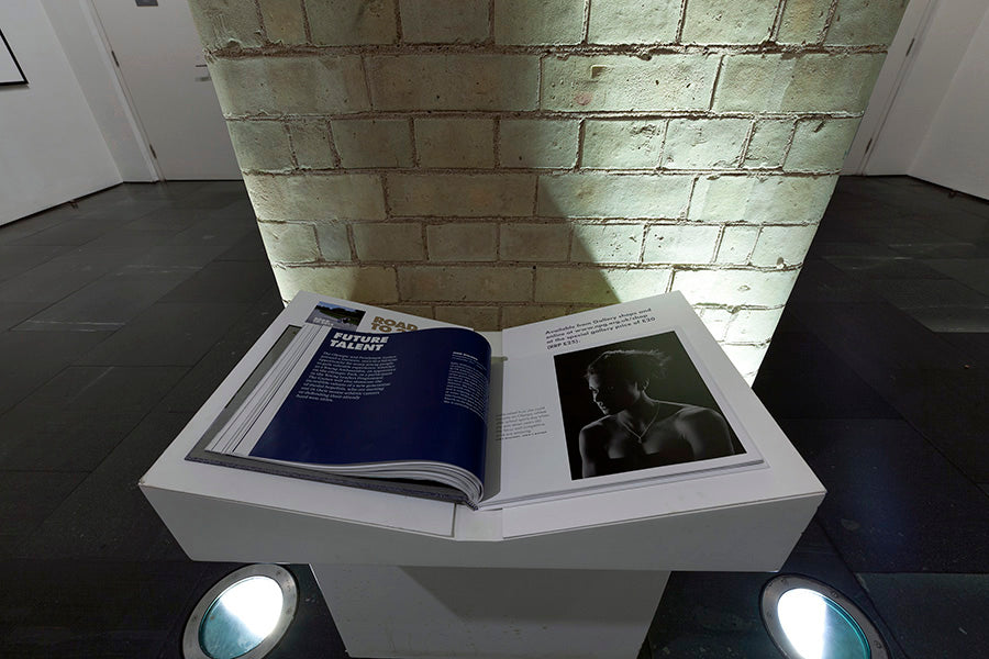 Open book on a stand against a brick wall